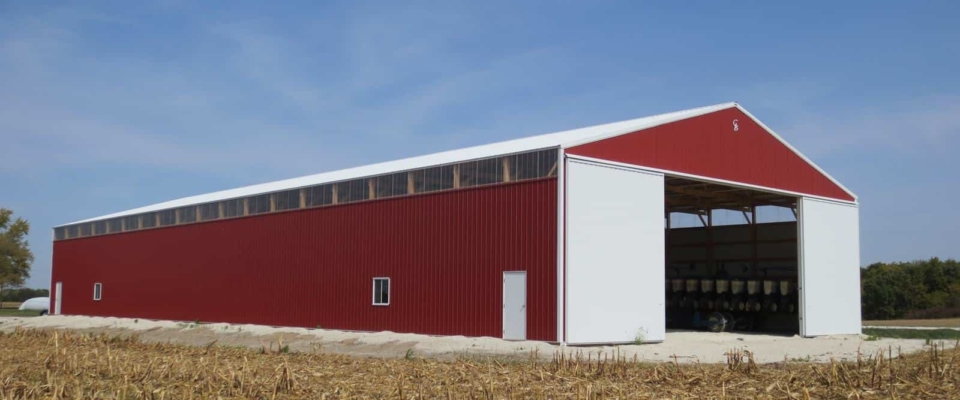 large red and white pole barn in cornfield