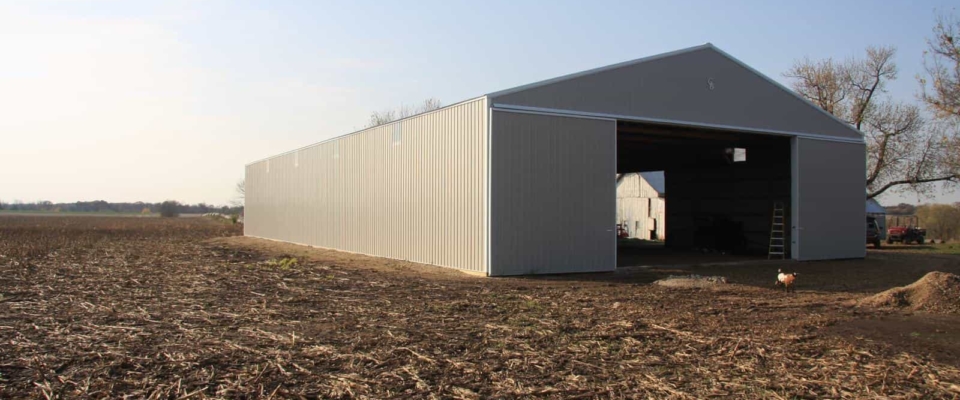 gray metal storage pole building in field
