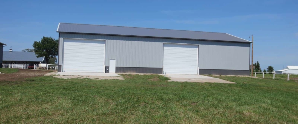gray machine shed farm building with white doors