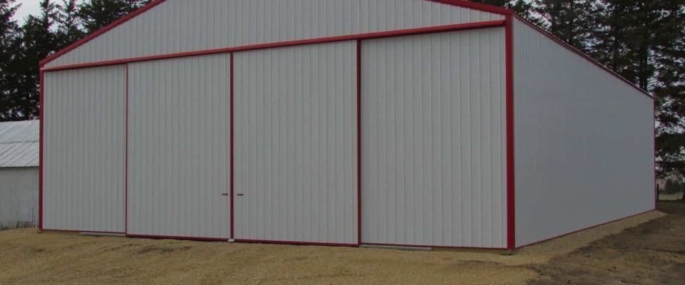 large white and red pole barn machine shed on farm