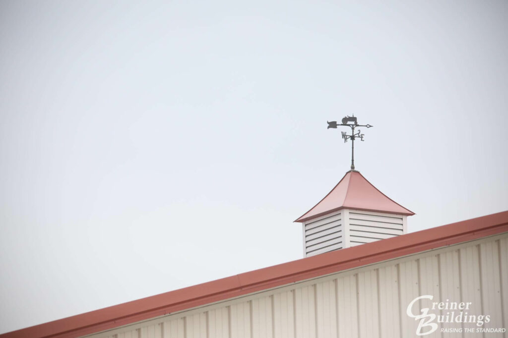 cupola and weather vane on top of farm pole building