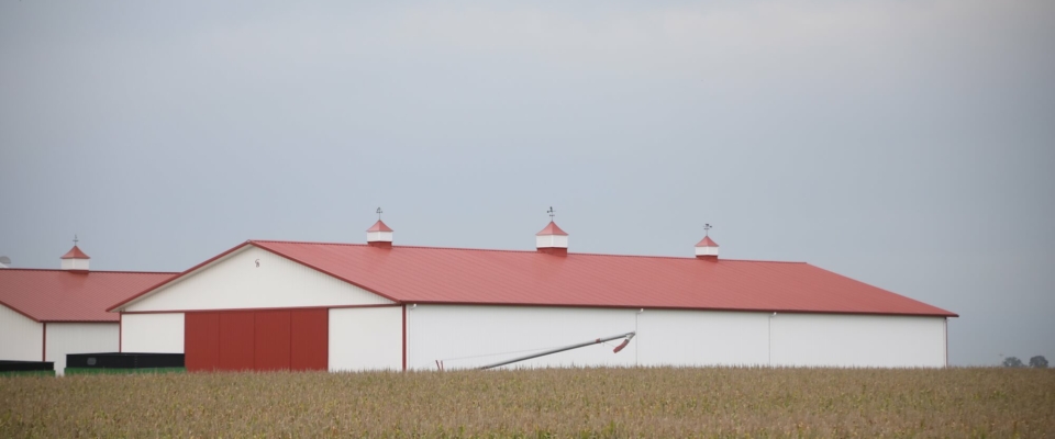 large red machine shed on farm with cupolas