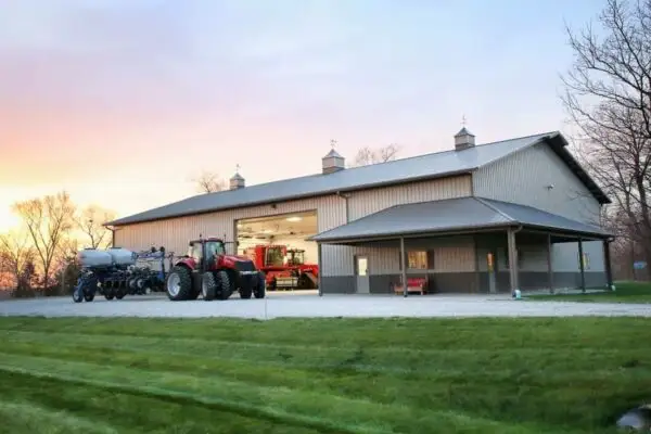 signature-series-large-tan-farm-pole-barn-with-tractor-covered-porch-cupolas-sunset