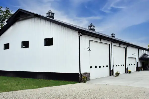 signature-series-large-white-pole-barn-black-trim-multiple-garage-doors-cupolas
