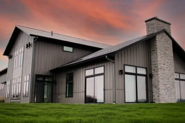 signature-series-modern-dark-grey-metal-building-stone-chimney-large-windows-rear-view