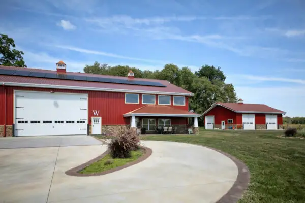 signature-series-red-barndominium-large-garage-covered-porch-solar-panels