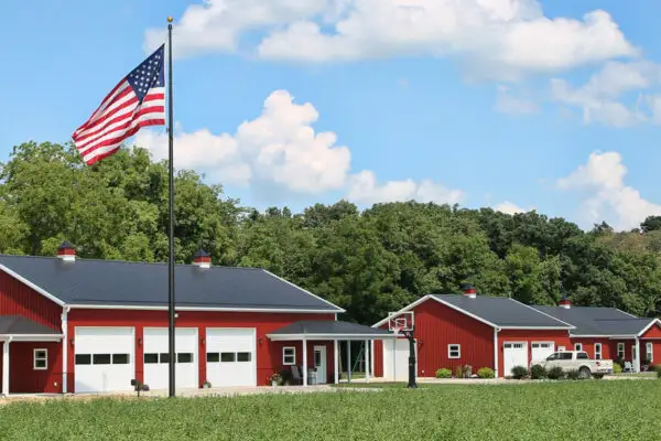 signature-series-two-red-pole-barns-white-garage-doors-american-flag-rural